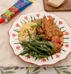 Pollo al pesto rosso con panna, orzo e fagiolini